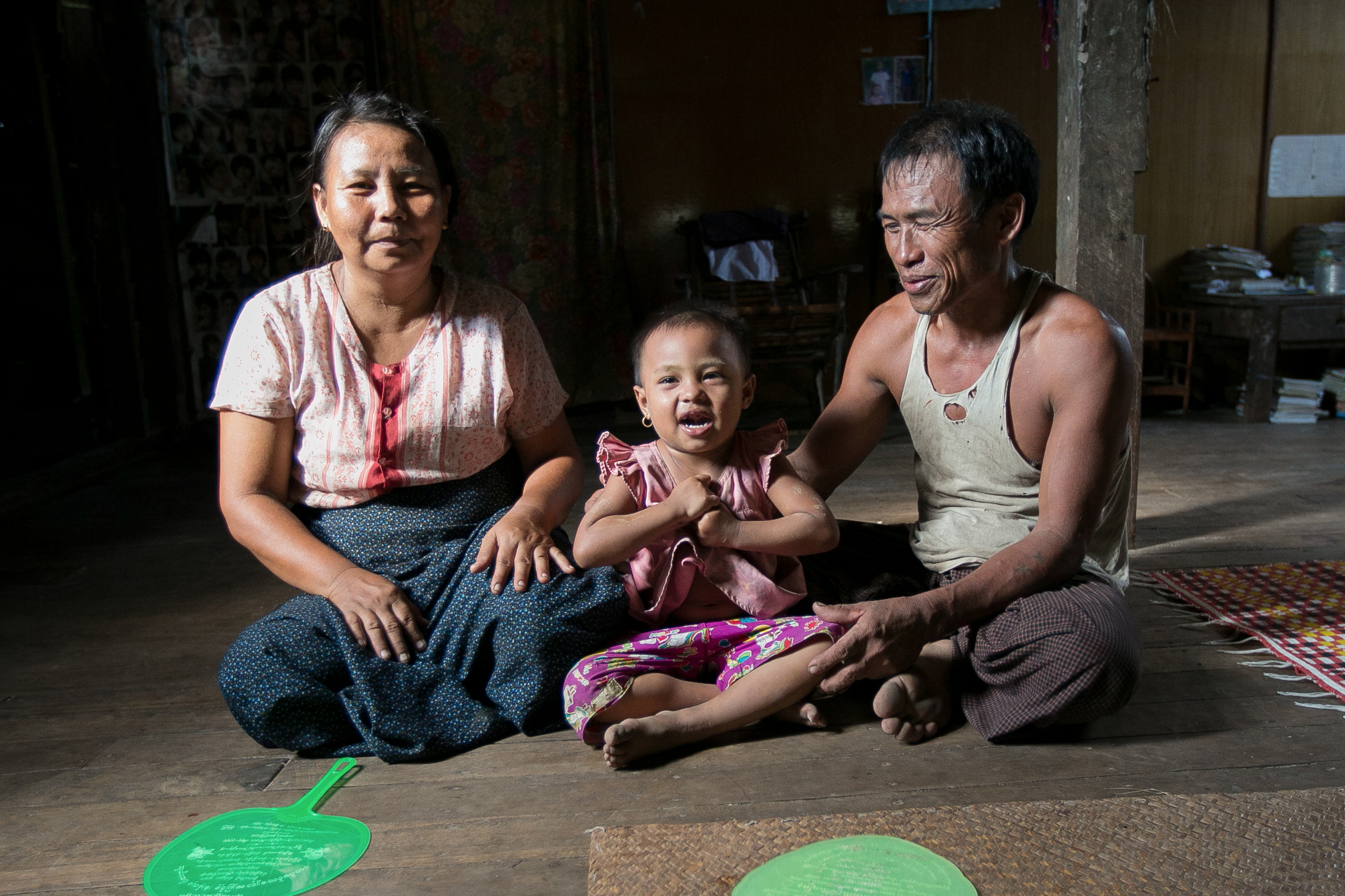 Photograph © Tim Mitzman for Proximity Designs 2013 U Myat Thein, an entrepreneurial farmer and now a village agent for Proximity Designs, grows corn as a cash crop in Wakouktaw village, Kungyangon township; with his wife, Daw Khin Ohn Myint, and their youngest child, daughter Thin Thin Myat, he welcomes visitors to their home—fans at the ready for the delta's heat and humidity.