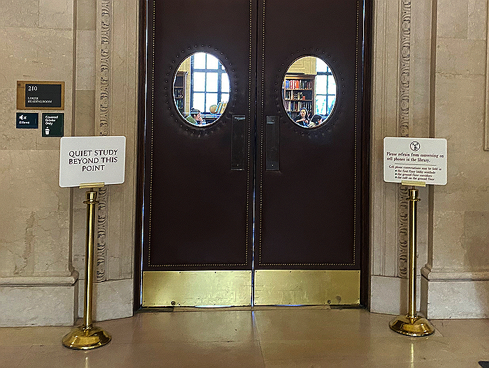 Closed doors of the reading room with signs on either side asking for quiet