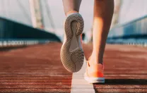 person's shoes while running on a bridge