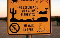 Near Winterhaven, California, an official sign faces south to warn illegal immigrants of dangers in the desert trek&mdash;heat, rugged terrain, rattlesnakes, lack of drinking water, a chance of drowning in a nearby canal&mdash;adding that it is not worth the risk.