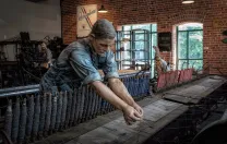 A replica of a textile mill shows life-like statues of workers. 