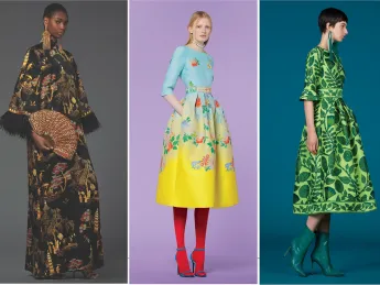 Three models showcase distinct fashions: a floral black gown, a blue top with a floral yellow skirt, and a green dress.