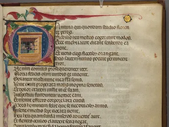 A page of medieval script with brightly colored initial letter and drawings in the margins