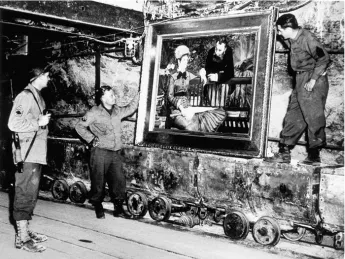 At the Merkers salt mines in central Germany, American GIs admire Édouard Manet’s <em>In the Conservatory,</em> one of the thousands of rare works and documents stored there by the Nazi regime late in World War II. Monuments Man George Stout (see next image), a Fogg Museum conservator turned U.S. Army lieutenant, supervised the rescue of 40 tons of art from the site in April 1945.