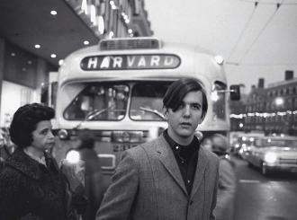 Gram Parsons stands in front of a bus in Harvard Square