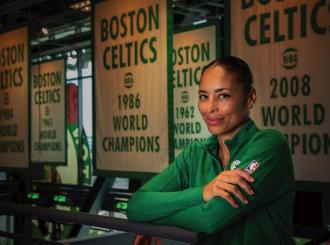 Allison Feaster wearing a green Celtics shirt in front of team championship banners