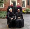 4 people standing in academic robes for photo op