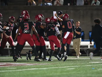 Harvard players celebrate after interception