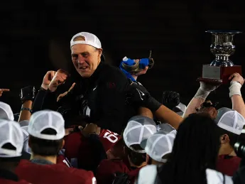 Coach Murphy is held up high by players in celebration
