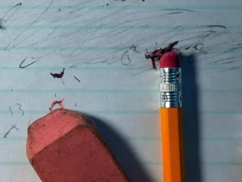 pencils and eraser fragments over an erased piece of paper