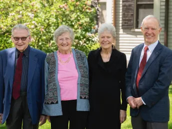 group of four people standing outside 