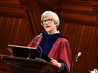 Drew Gilpin Faust in robes at the podium in Sanders Theater