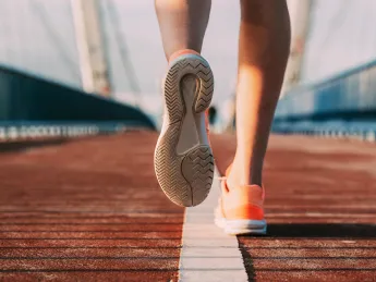 person's shoes while running on a bridge