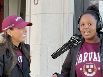 A woman interviews a Harvard student with a "tiny mic" about her plans for the Harvard-Yale game this year
