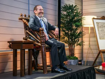 President Garber sitting in a wood chair on a platform