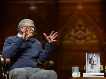 Bill Gates delivers comments at Harvard University, his memoir Source Code displayed