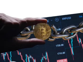 Cryptocurrencies are forms of digital assets stored on blockchains; image depicts hand holding representation of bitcoin over chain