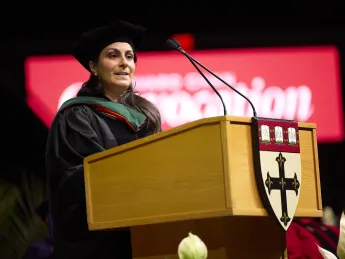 Céline R. Gounder speaks at a podium