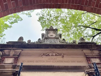 Harvard University entrance with inscription reading "Depart to Serve Better Thy Country and Thy Kind"