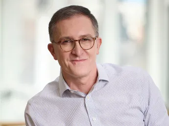 Man wearing a white collared shirt and glasses. 
