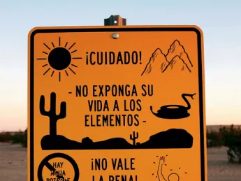 Near Winterhaven, California, an official sign faces south to warn illegal immigrants of dangers in the desert trek&mdash;heat, rugged terrain, rattlesnakes, lack of drinking water, a chance of drowning in a nearby canal&mdash;adding that it is not worth the risk.
