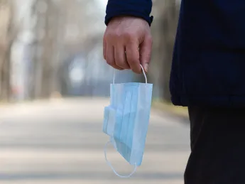 A hand holding a face mask