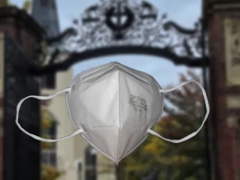 n95 mask in the foreground, Harvard Yard in the background 