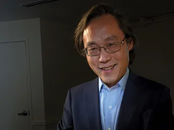 Frank Hu holds a plate filled with food. 