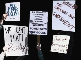 A photo montage of protest signs; one reads, "Workers are Harvard's true endowment."