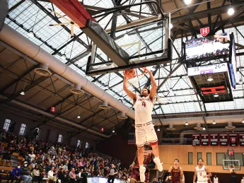 Chris Ledlum dunks the ball in the basket as opposing players trail behind him