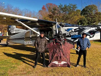 Alejandro Montagna standing in front of a small airplane wearing a wingsuit