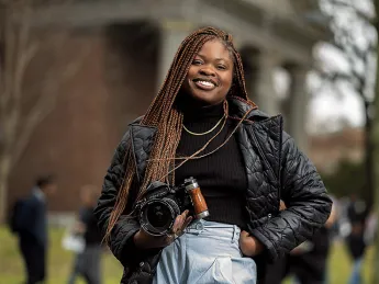 Dumb Menakaya standing on campus with her camera