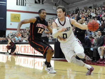 Senior captain Laurent Rivard drives past Princeton's Ben Hazel at Lavietes Pavilion. The Crimson swept both the Penn and Princeton home-and-away series this year for the first time in history.