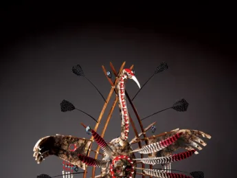 In Yup’ik lore, the crane—depicted in the mask above—connotes stealth, power, and insight. The human face on the bird’s belly represents its <em>yua,</em> or spirit—the part of the animal that understands, and can relate to, humans. The porcelain “teeth” that border the face are a reminder to use one’s innate gifts to good effect, or risk being consumed by them. The porcelain “bones” hanging from the wings ward off evil spirits; wooden rings represent this world and the spirit world.