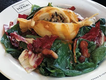 Duck tamale on spinach salad with a warm bacon and mustard dressing from Chez Henri