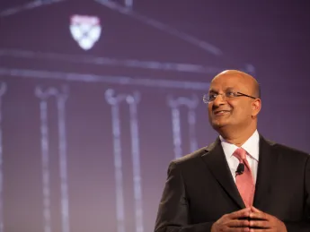HBS dean Nitin Nohria during his campaign address April 25; a sketch of the iconic Baker Library, with the HBS crest, is projected behind him. 