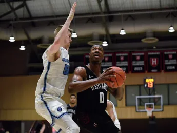 Chris Lewis, ball in hand, drives past opponent