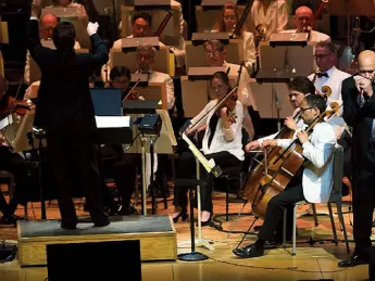 Johnson plays his harmonica with the Boston Pops orchestra behind him.