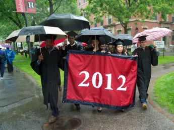 Class marshal Oluwadamilola “Dammy” Akinfenwa, class treasurer Marta Bralic, and class marshals Athena Lao and Matthew DaSilva carry the seniors’ banner.
