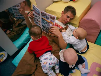 This teenager regularly hurries from  his job to a local day-care center to  spend time with his son in his new role  as a father.