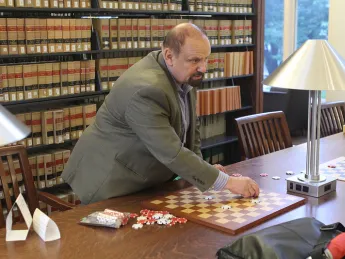 International draughts master Alex Mogilyansky with board and checkers in Langdell Library
