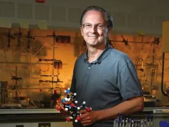 Jack Szostak, in his lab at Massachusetts General Hospital, holds a model of a nucleic acid.