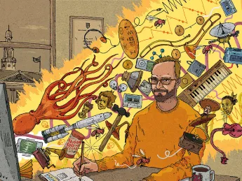 A professor sits at a computer whose screen is shooting out a beam of light filled with all sorts of animals and musical instruments