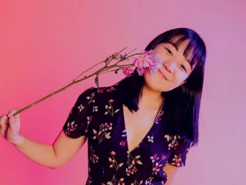 Karen Chee holding a flower to her face