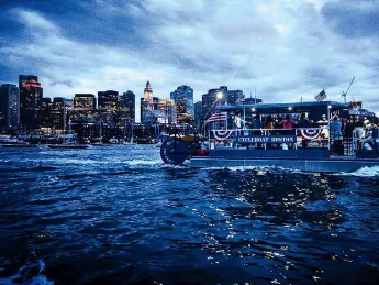 Boat cruising on Boston harbor at twilight 