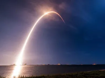 A time-lapse exposure of the SpaceX rocket carrying TEMPO into orbit reveals an arc of light against the sky.