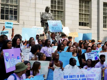 Photograph of student rally against the Supreme Court decision with the John Harvard statue in the background