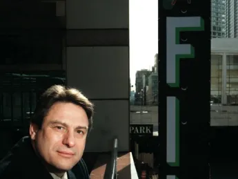 Richard Peña at Lincoln Center, with a New York Film Festival banner at right, behind him
