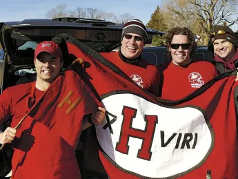 Members of the undefeated 2001 Crimson football team show flags at a 2011 tailgate in New Haven. Jared Lewis &rsquo;02, far left, holds the ancient Little Red Flag, which has been to many Harvard-Yale football games. He designed the new flag, and Kelly Goff made it. It is brandished, from left, by Justin Stark &rsquo;02, Jason Hove &rsquo;02, and Samuel Taylor &rsquo;02.