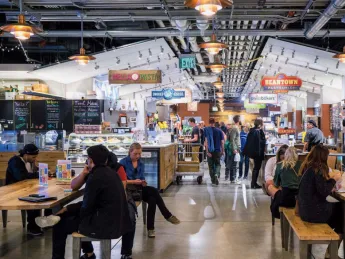 An indoor photo of people eating and shopping at Boston Public Market